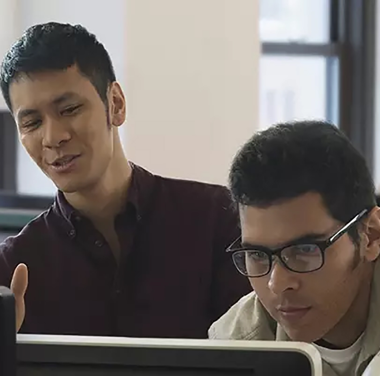 Dois colegas de trabalho colaboram em um computador.