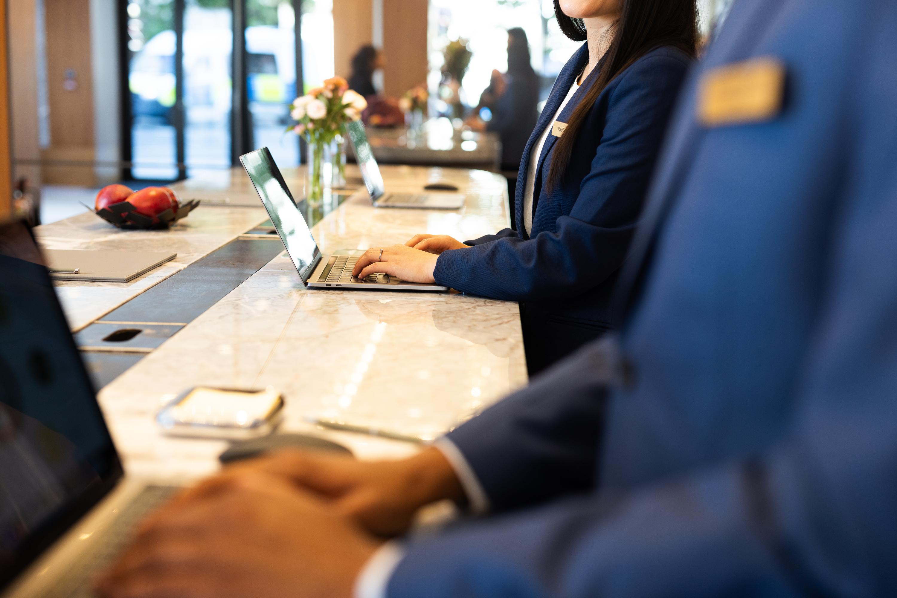 Hotel receptionists at laptops.