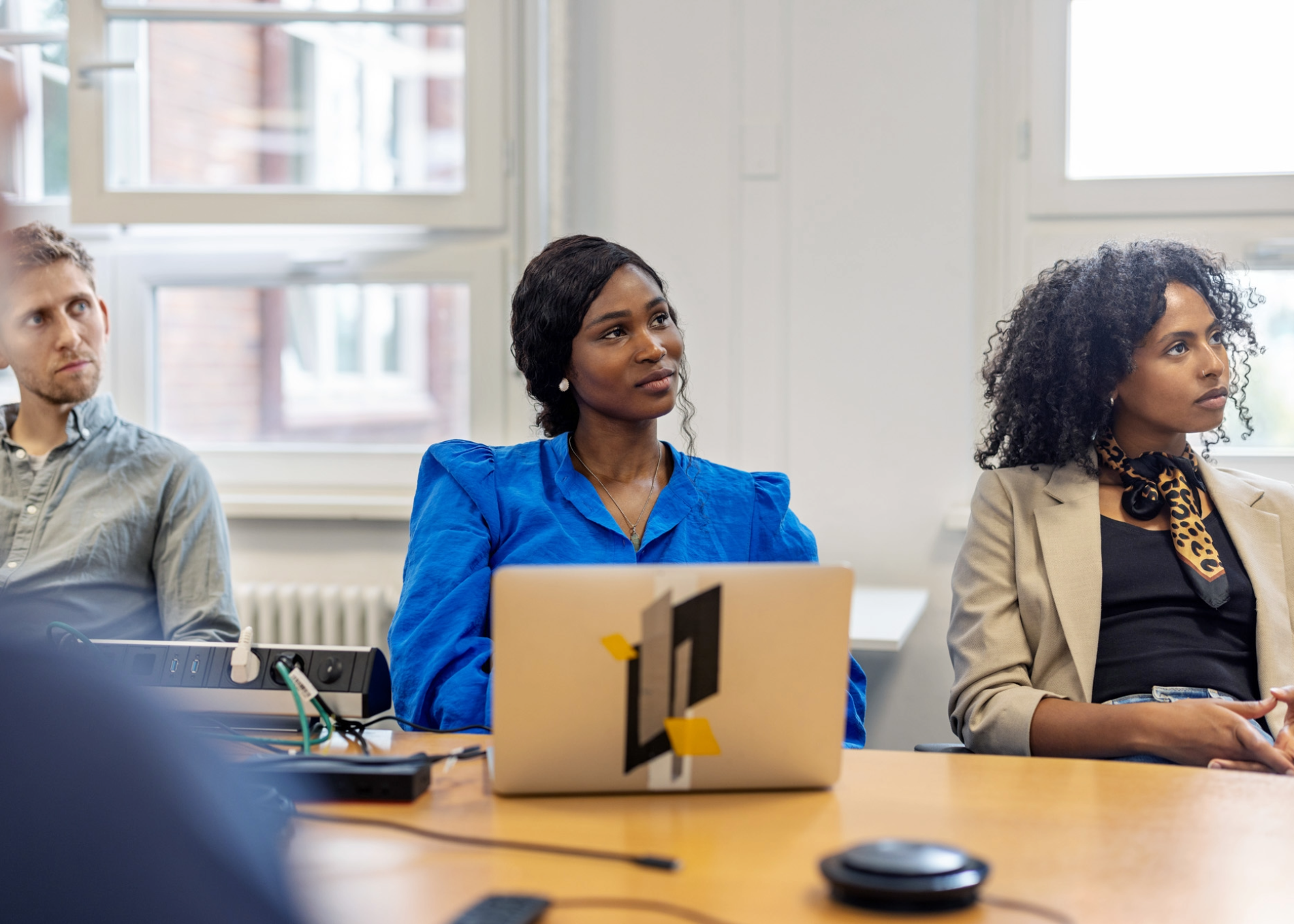 Diverse group of employees listens attentively in a meeting.