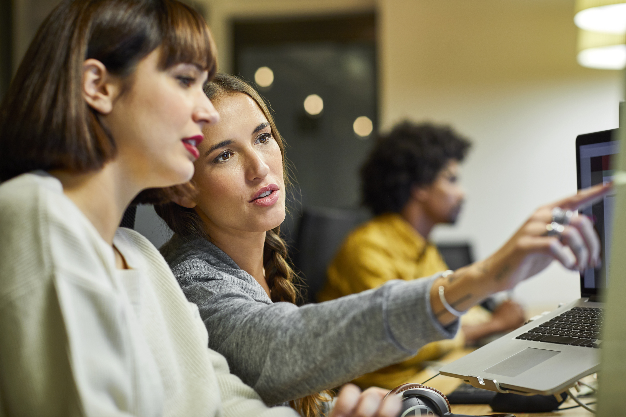 Dois colegas de trabalho colaboram em um computador.