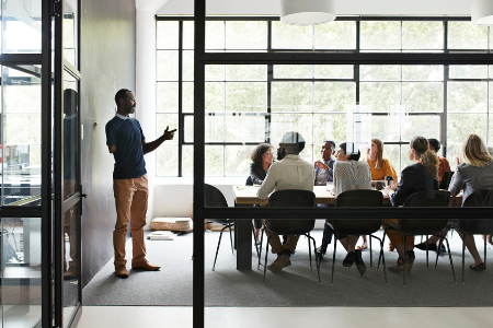 Um apresentador falando para um grupo de colegas de trabalho.