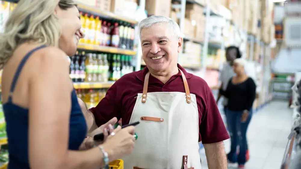 Smiling store employee helps a customer.
