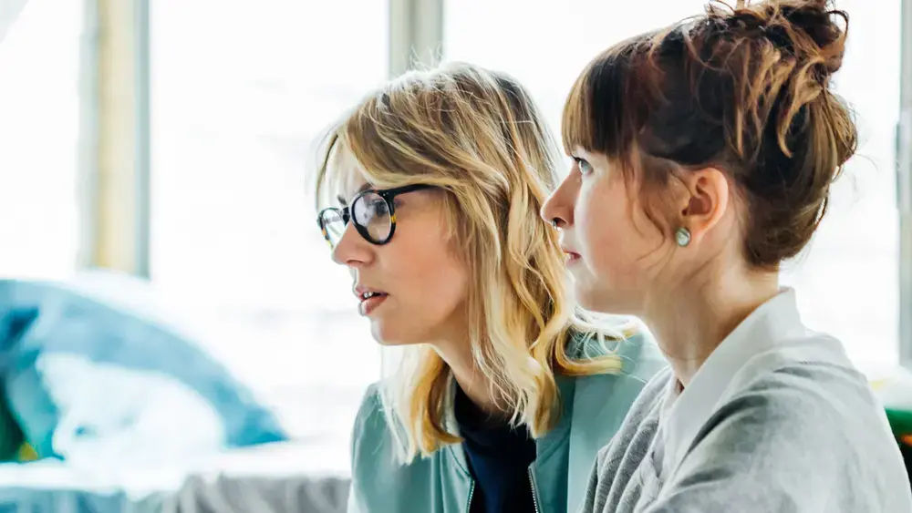 Two coworkers collaborate at a computer.