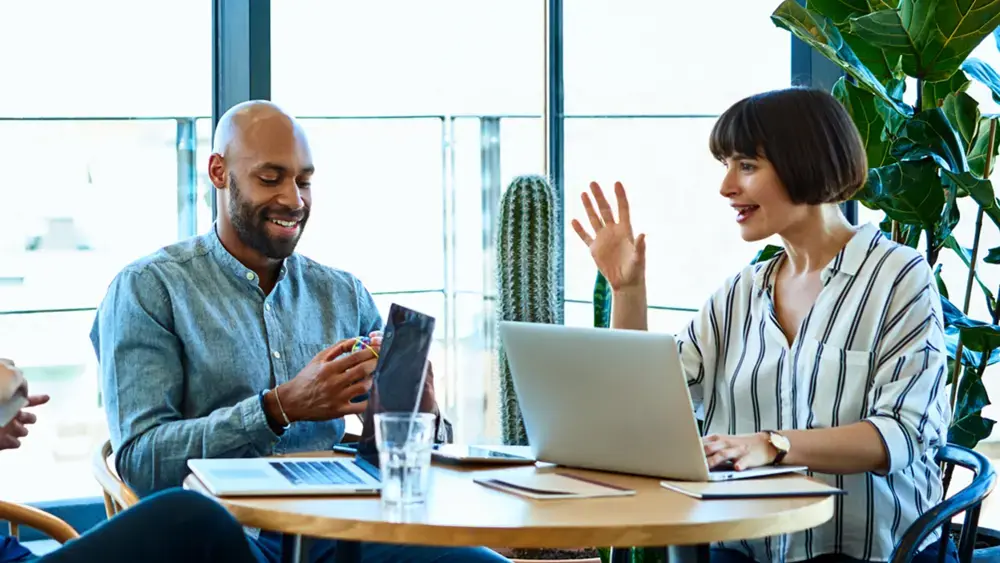 A cross-functional team collaborates around a round table.