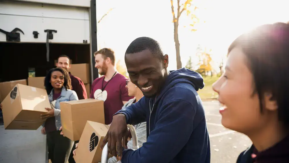 Voluntários carregam caixas em um caminhão.