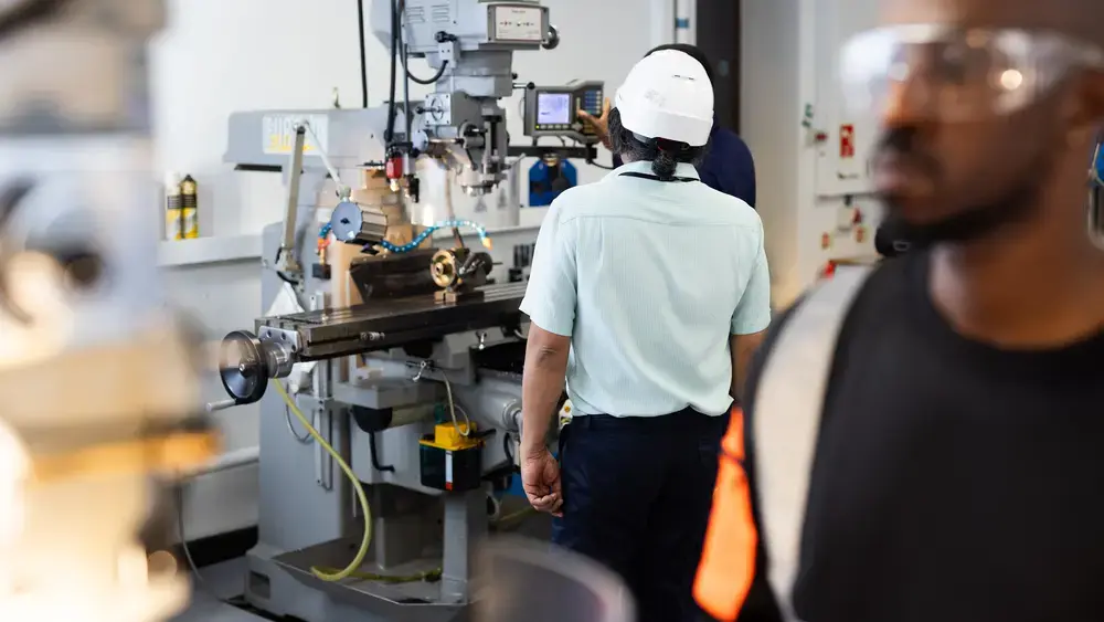 Workers operating machinery in a factory.