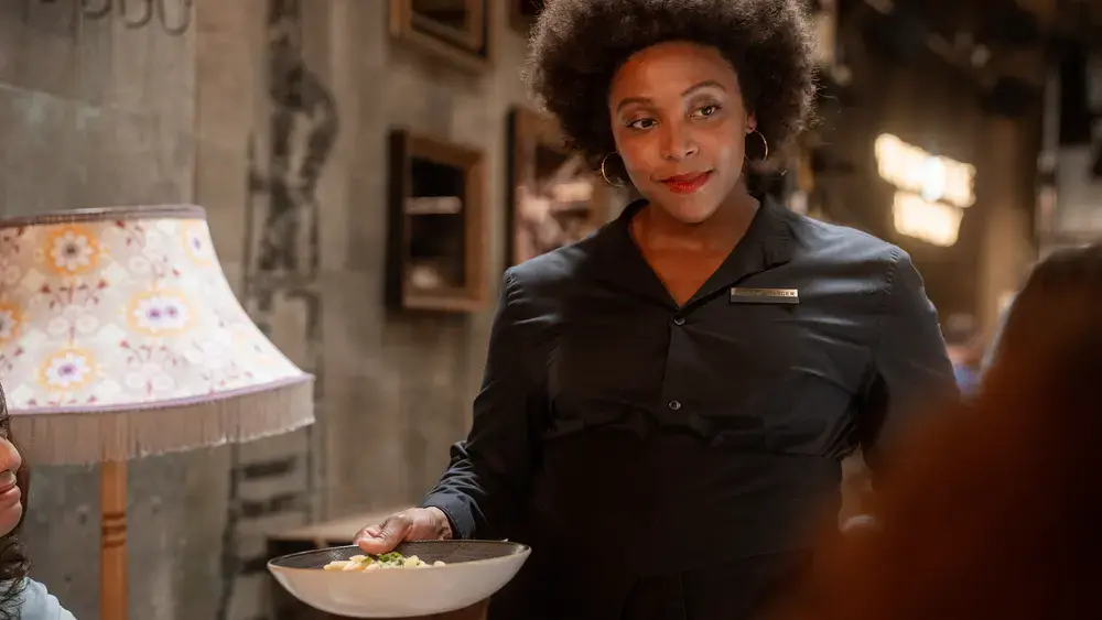 A waitress with a smile serving food.