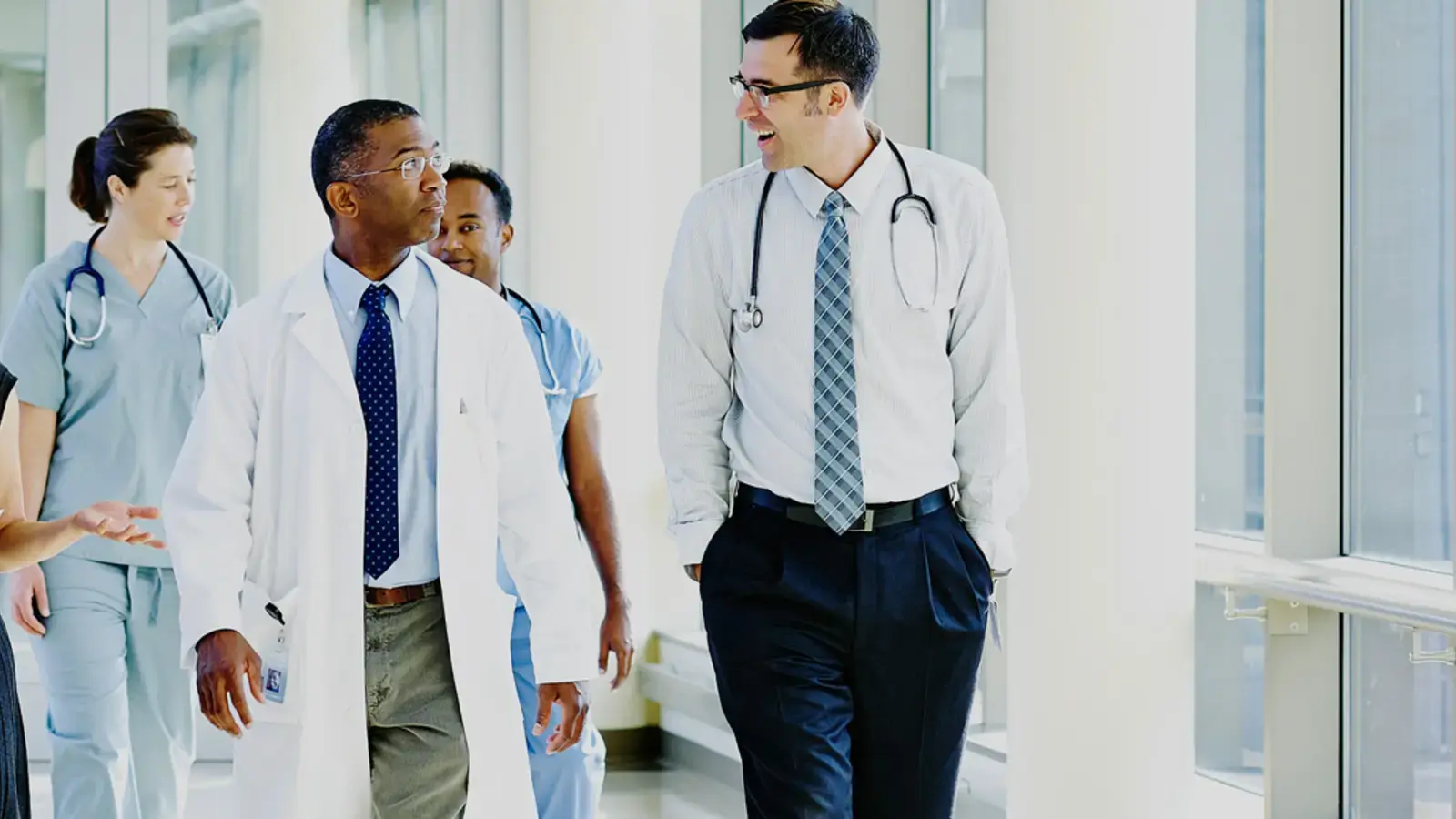 Healthcare workers walking in a hospital hallway.