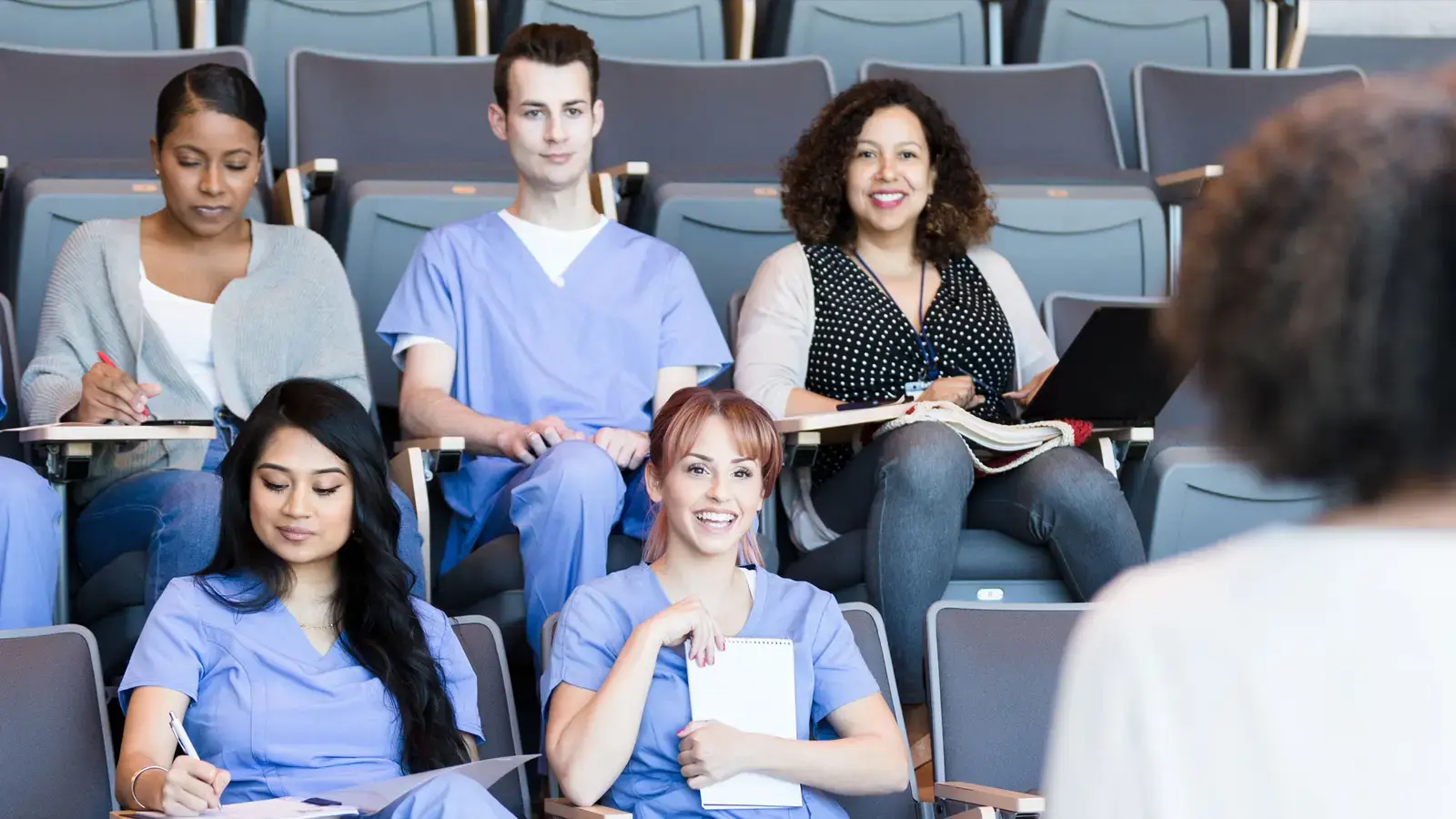 Attentive healthcare workers listen to a lecture.