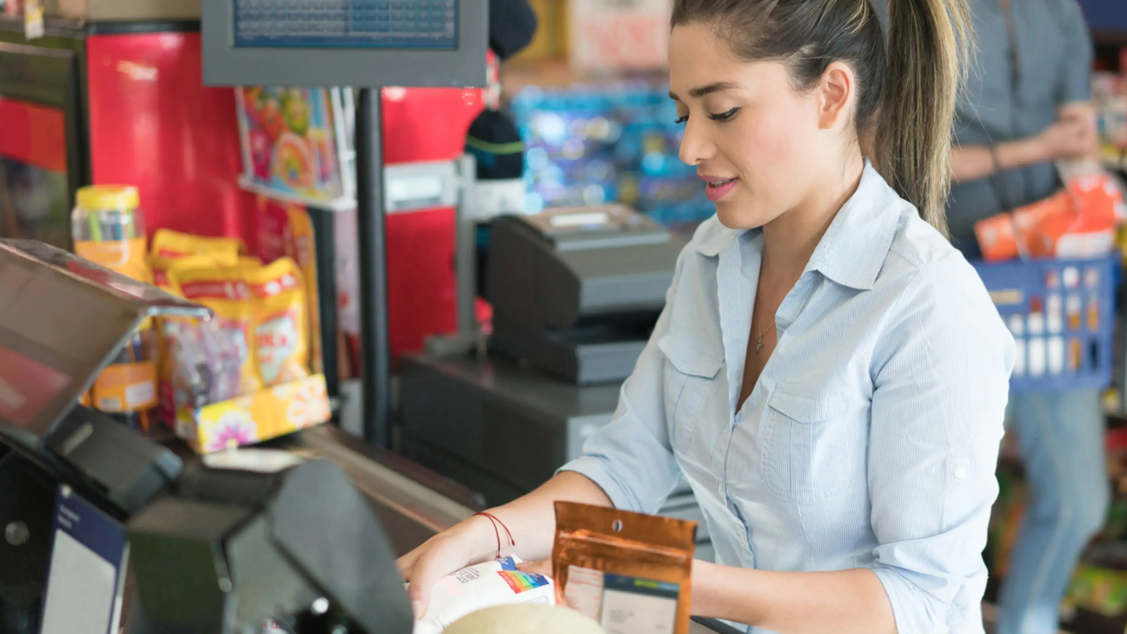 Uma mulher em um supermercado ajudando um cliente.