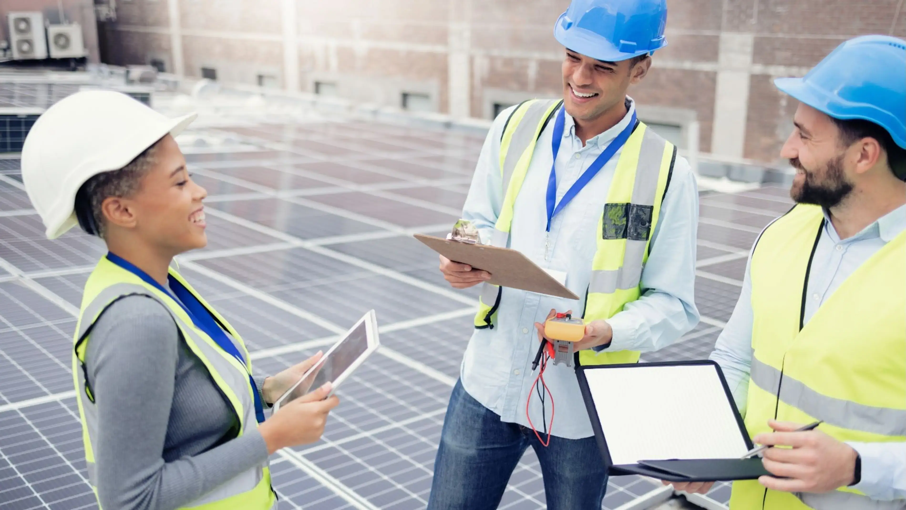 Three energy coworkers collaborating on an on-site solar panel project.
