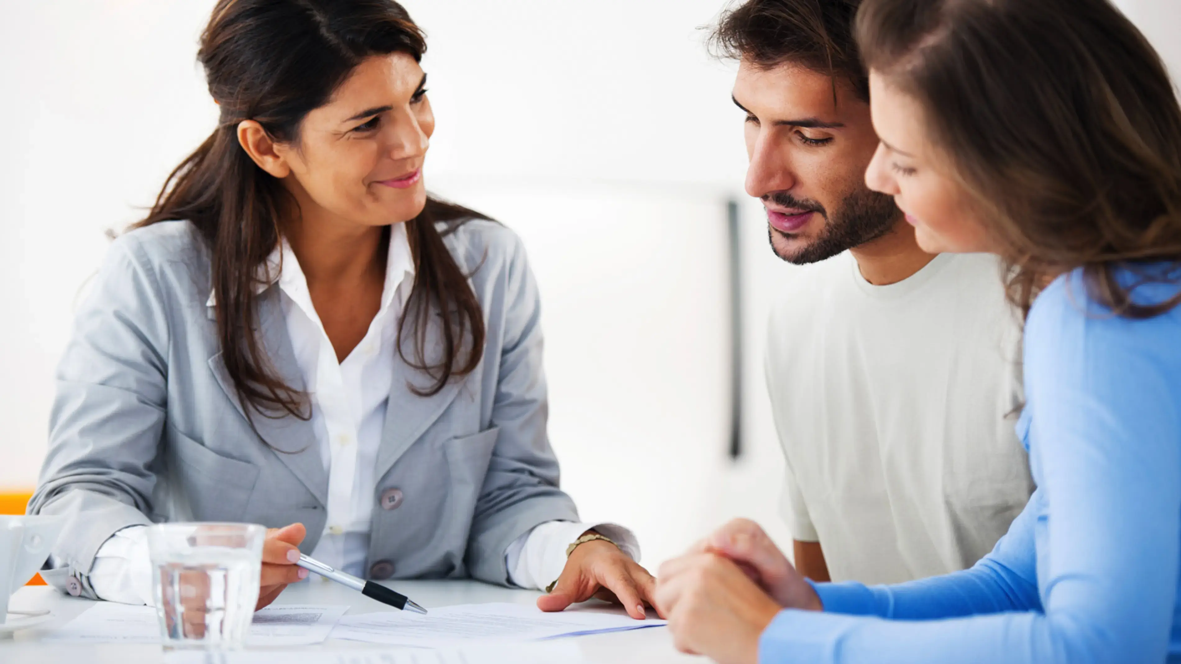 A professional shares a paper with a couple, discussing strategy.