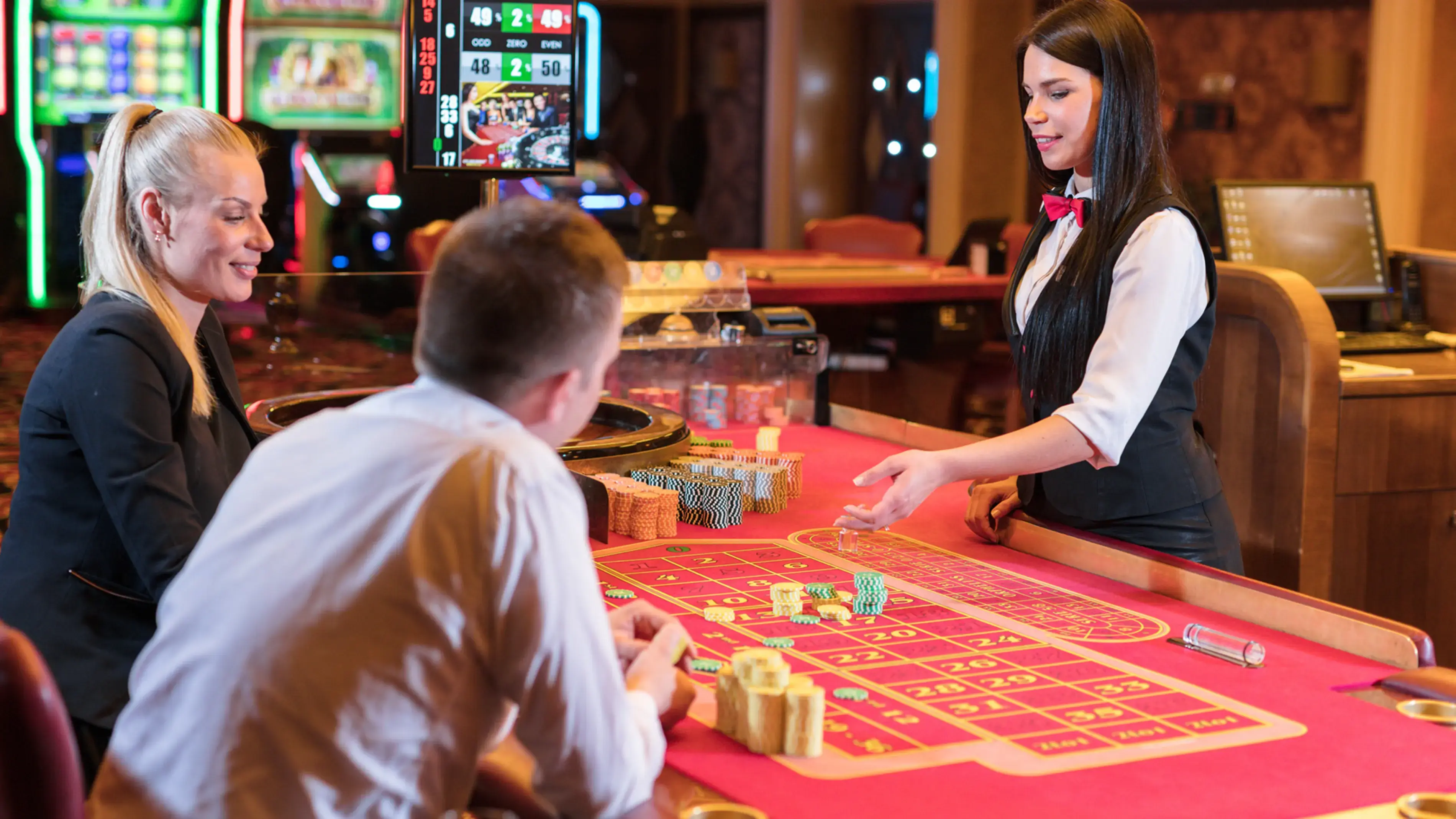 A casino, people and a casino worker at a red dice game table.