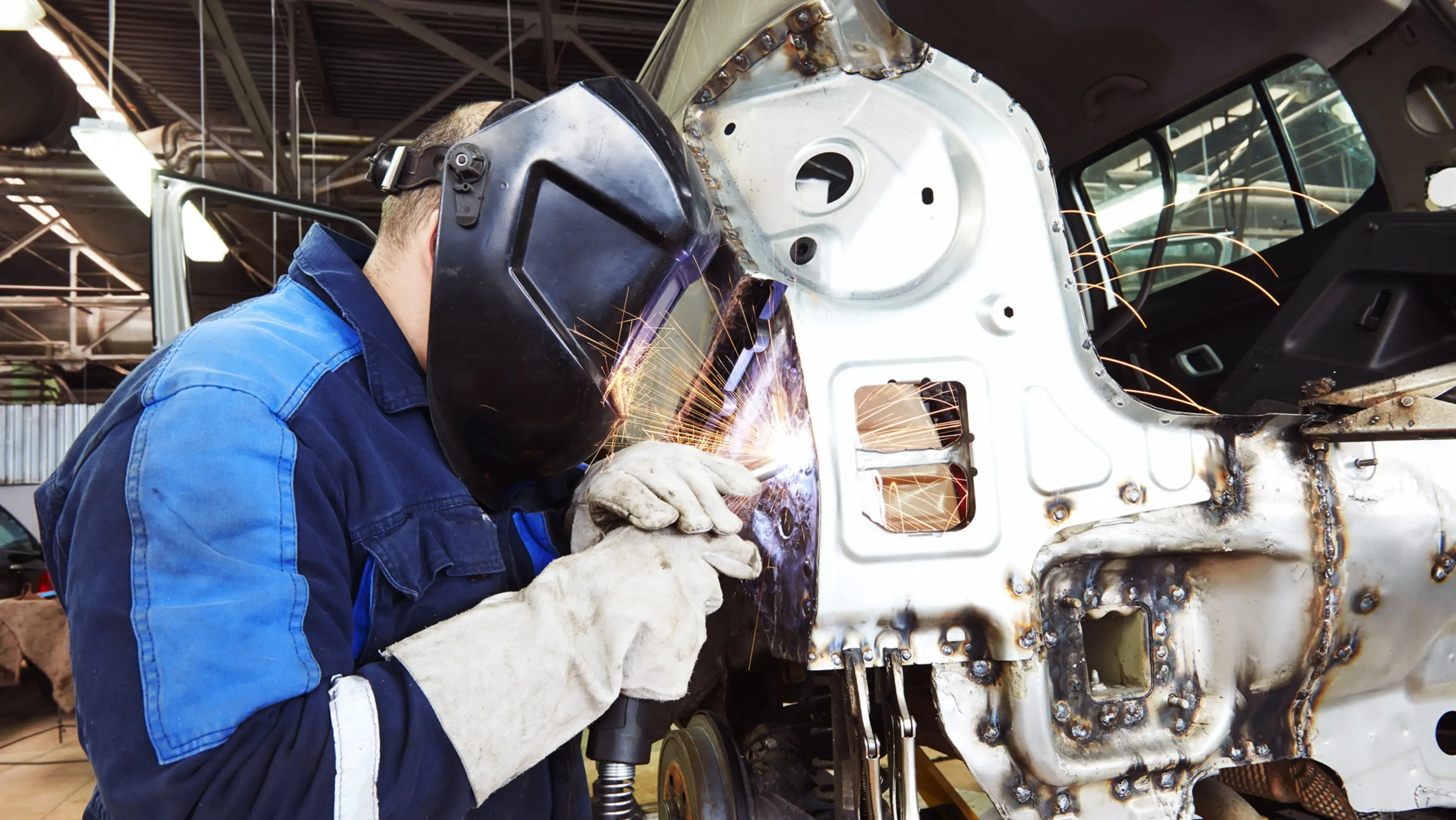 A mechanic uses a welder, performing an on-site repair.