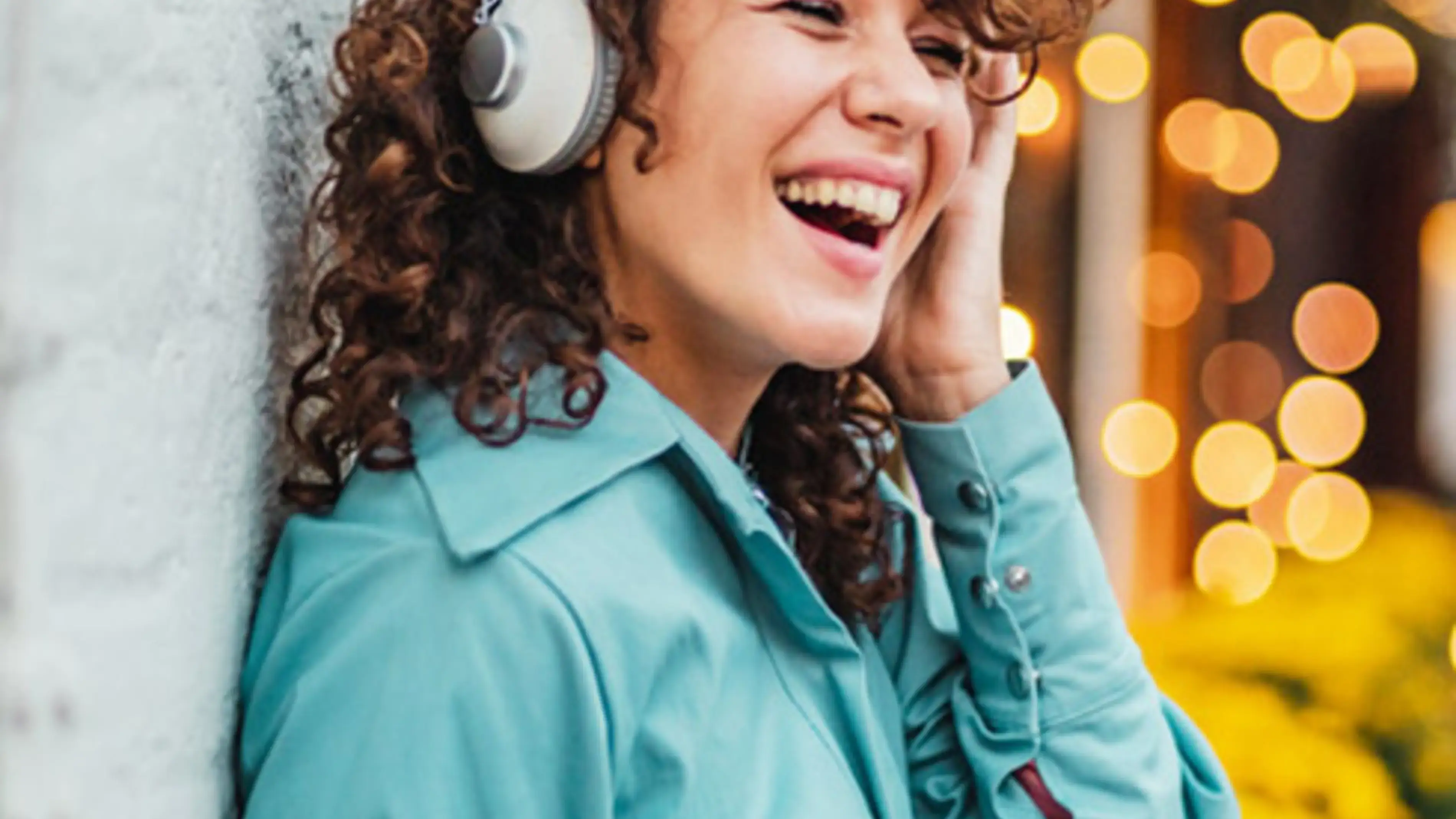 Mulher usando fones de ouvido, sorrindo, ouvindo música, em tempo real.