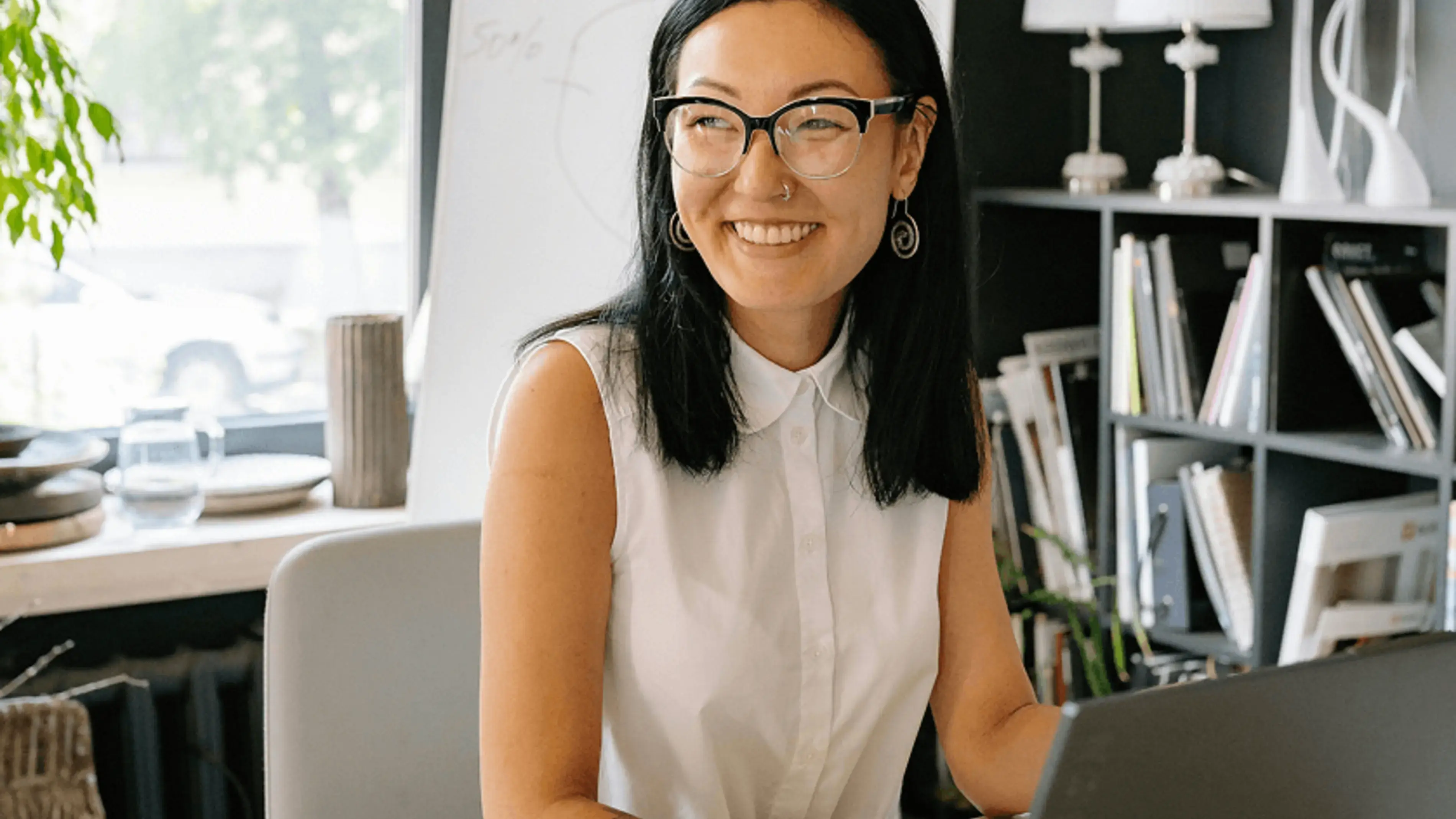 Smiling woman working on laptop.