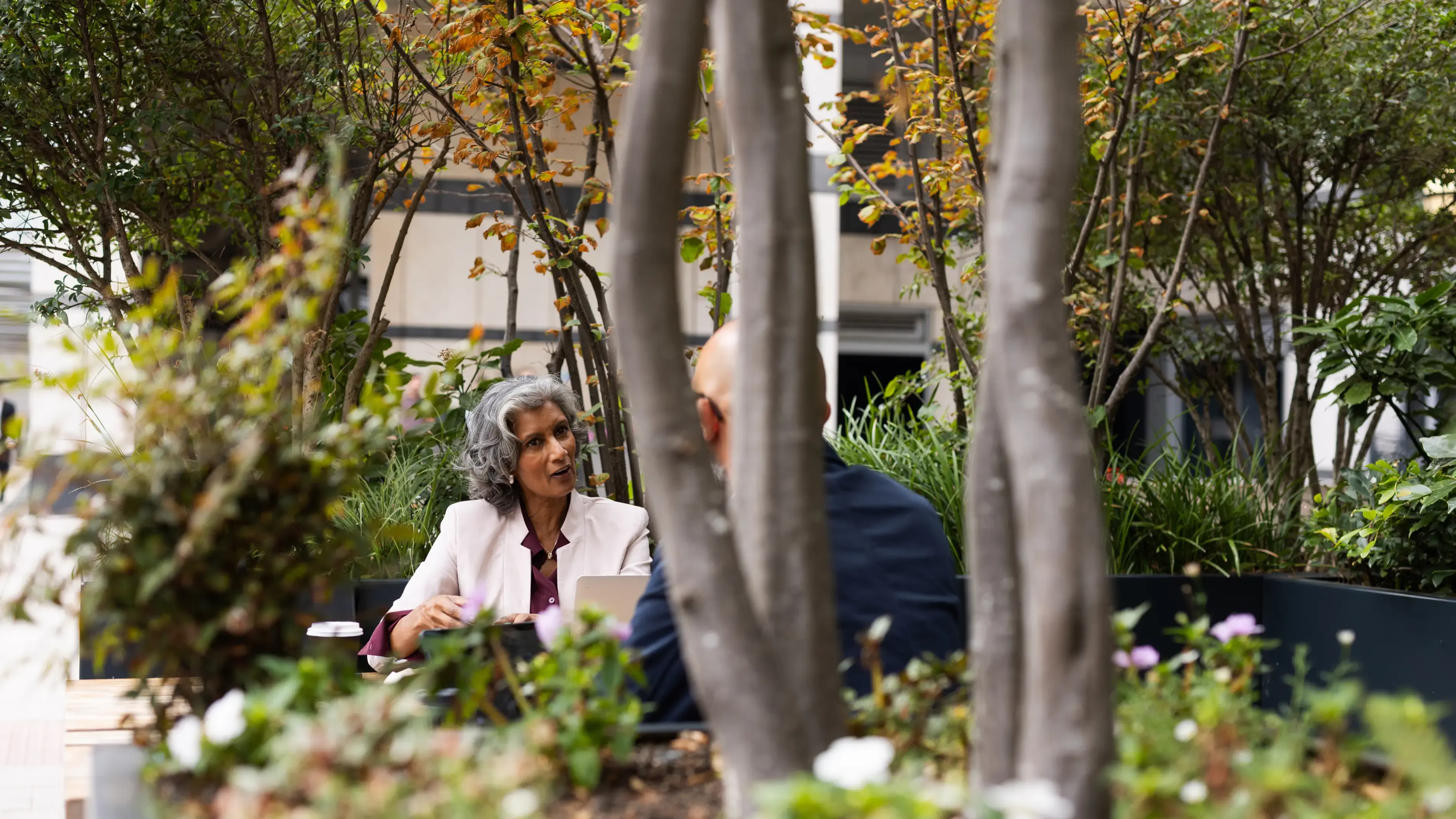 Two coworkers have a meeting outdoors.