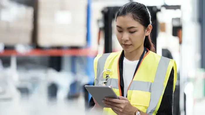 A warehouse worker reviews a tablet.
