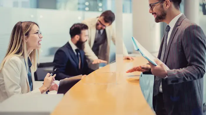 Businesspeople collaborating at a reception desk.
