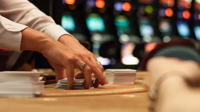 Close-up of hands dealing cards at a casino table.
