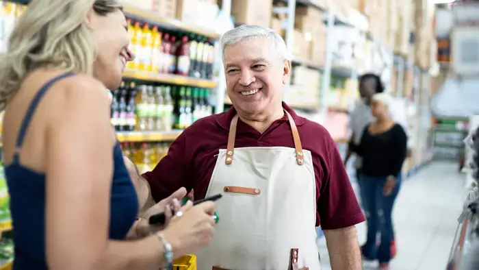 Smiling store employee helps a customer.
