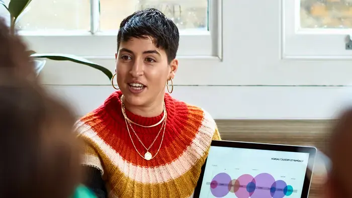 Person presenting a data graph on a laptop.