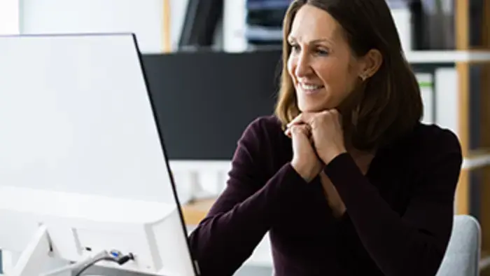 Um colega de trabalho online sorri para o computador.