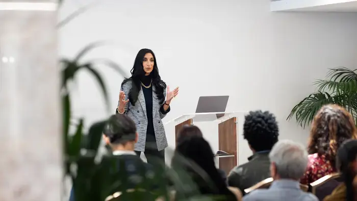 Woman giving a presentation in front of a group.