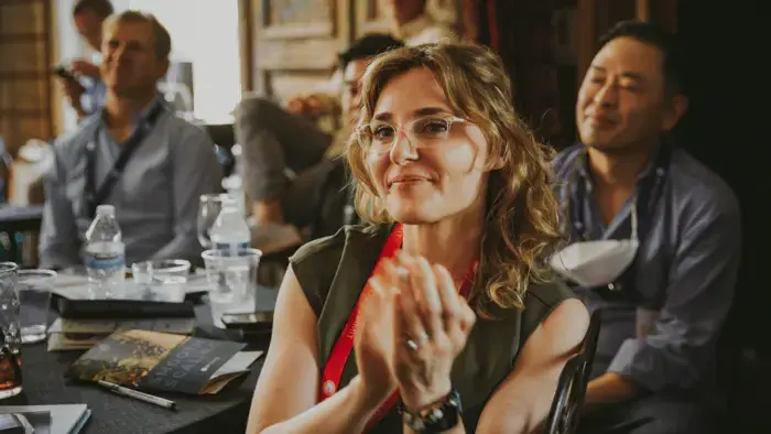 Smiling woman watching a presentation with a group of coworkers