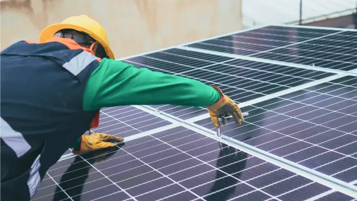 Worker inspecting solar panels.