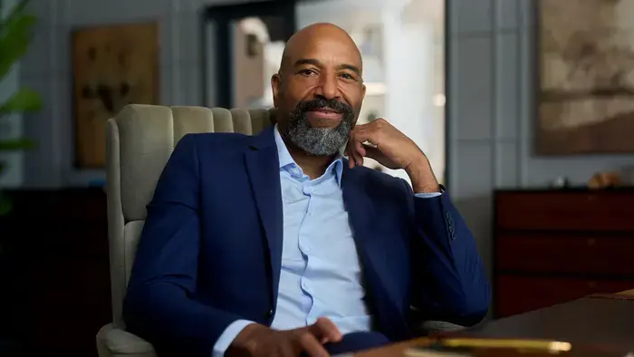 Portrait of a smiling man in a blue suit.