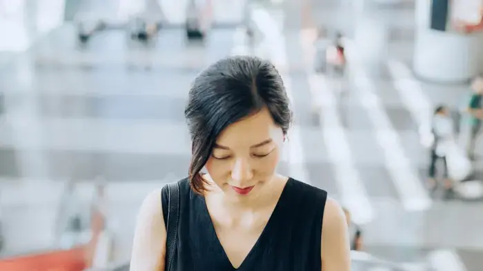 Woman on an escalator using her smartphone.