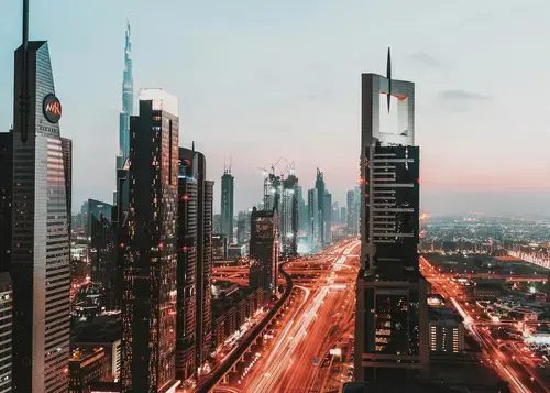 An aerial view of Dubai's skyline, showcasing illuminated skyscrapers.
