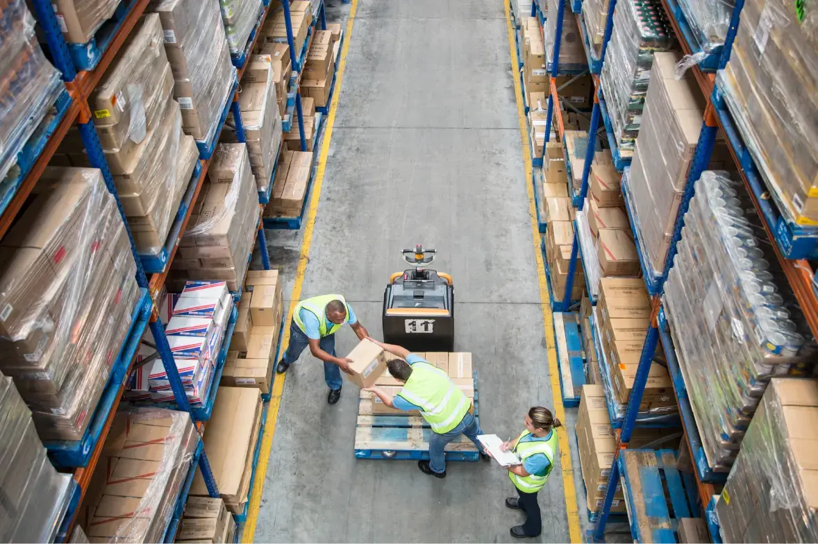 Workers load packages in an industrial warehouse, a workflow in action.